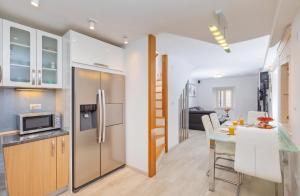 a kitchen and dining room with a table and a refrigerator at Domino Holiday Home in Dubrovnik