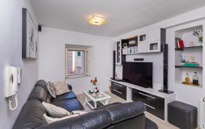 a living room with a leather couch and a television at Domino Holiday Home in Dubrovnik