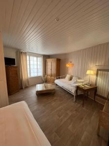 1 dormitorio grande con 1 cama y 1 mesa en Hôtel Le Vieux Gréement en La Couarde-sur-Mer