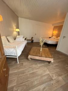 een kamer met 2 bedden en een salontafel bij Hôtel Le Vieux Gréement in La Couarde-sur-Mer