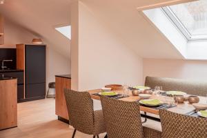 a dining room with a wooden table and chairs at FOREST Private Suites in Titisee-Neustadt