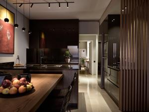 a kitchen with a table with a bowl of fruit on it at Monopolio Waterfront Apartment Zakynthos in Zakynthos