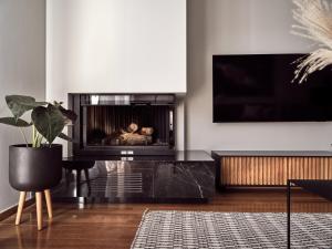 a living room with a fireplace and a tv at Monopolio Waterfront Apartment Zakynthos in Zakynthos Town