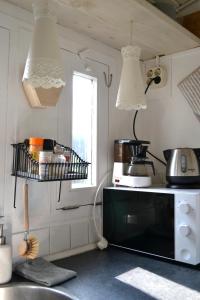 a kitchen with a microwave and a shelf on the counter at Pipowagen Lent in De Pas