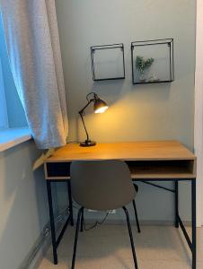 a desk with a lamp and a chair next to a window at Anker Apartment – Grünerløkka in Oslo