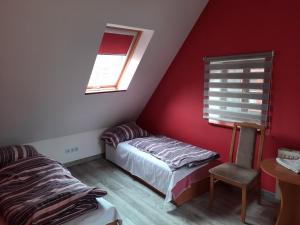 a bedroom with a bed and a window and a chair at Pokoje gościnne w centrum in Bogatynia