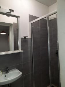 a bathroom with a shower and a sink and a mirror at Pokoje gościnne w centrum in Bogatynia