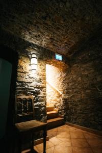 a room with a stone wall with stairs and a light at Hotel am Bahnhof in Weilburg