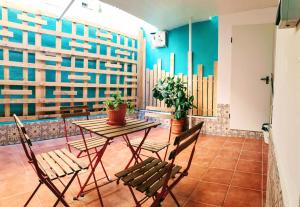 uma mesa e cadeiras num quarto com uma parede azul em Recien renovado junto a Santa Justa y el centro em Sevilha