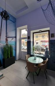 Una habitación con una mesa y sillas y una ventana. en Sleeping Sailor Boutique Hotel, en Siófok