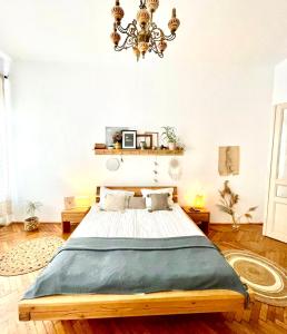 1 dormitorio con cama y lámpara de araña en Camino Home, en Cluj-Napoca