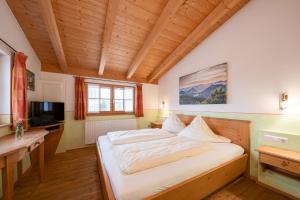 ein Schlafzimmer mit einem großen Bett in einem Zimmer mit Holzdecke in der Unterkunft Berggasthof Hotel Duftbräu I Ruhige Alleinlage I Mitten im Grünen in Samerberg