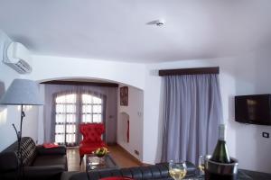 sala de estar con sofá y silla roja en El Pacha Suites Sharm - Adults Only en Sharm El Sheikh