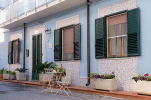 a house with green shutters and plants in front of it at Stella Maris Marzamemi Apartments in Marzamemi