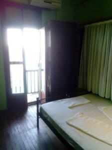 een slaapkamer met een bed en een groot raam bij Apartments in Mylopotamos in Milopotamos