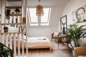 a bedroom with a crib and a chair and a plant at V10 B Apartment in Pécs