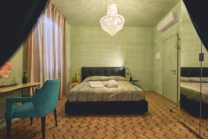 um quarto com uma cama, uma secretária e uma cadeira em Le Stagioni Luxury Suite em Forlì