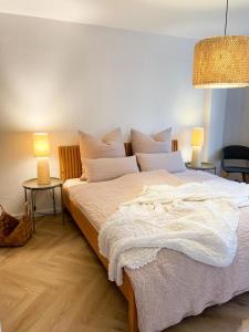 sypialnia z dużym białym łóżkiem z 2 lampami w obiekcie Ferienwohnung Ava No3- Heiligkreuztal 2-3 Personen w mieście Heiligkreuztal