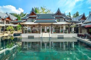 una casa con piscina frente a ella en Baan Yin Dee Boutique Resort Phuket - SHA Plus, en Patong Beach