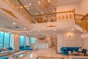 a large living room with a staircase and blue furniture at Kingdom Hotel Cua Lo in Cửa Lò