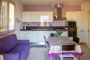 cocina con mesa y sofá púrpura en House Pantanello Beach - SiciliaVacanza, en Avola