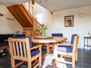 uma sala de jantar com uma mesa de madeira e cadeiras em Old Spot Cottage em Goodwick