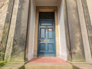 a blue door in a building with two columns at Windyridge in Settle
