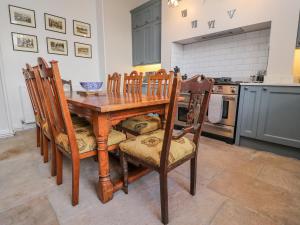 a kitchen with a wooden dining table and chairs at Windyridge in Settle