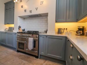 a kitchen with blue cabinets and a stove at Windyridge in Settle