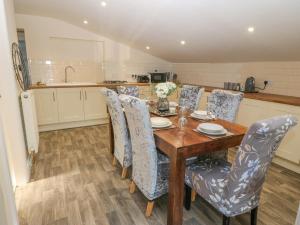 a dining room with a wooden table and chairs at The Apartment at Plas Yr Eithin in Amlwch