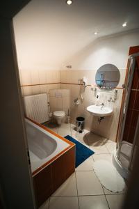 a bathroom with a tub and a toilet and a sink at Hotel am Bahnhof in Weilburg