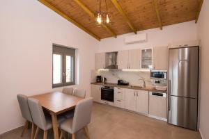 a kitchen with a table and a stainless steel refrigerator at Amousso Bay Villas in Marantochori