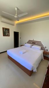 a bedroom with a large bed in a room at Beach Walk Villa Maldives in Gulhi