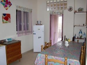 eine Küche mit einem Tisch und einem weißen Kühlschrank in der Unterkunft villa virginia in Policastro Bussentino