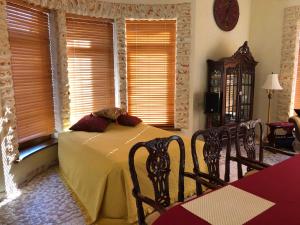 a bedroom with a bed and two chairs and windows at Guests house with amazing pool and sauna in Babīte