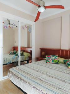 um quarto com 2 camas e uma ventoinha de tecto em Los Pinos em La Pineda