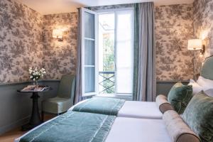a bedroom with a large bed and a window at Hotel du Champ de Mars in Paris