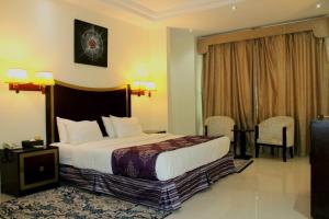 Un pat sau paturi într-o cameră la Tourist Hotel