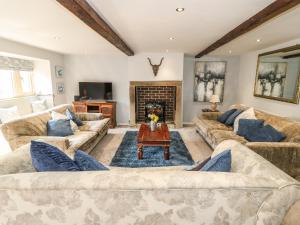 a living room with couches and a fireplace at Kingfisher Cottage in Holmfirth