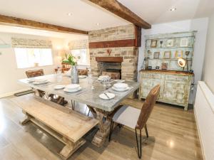 a dining room with a table and chairs and a fireplace at Kingfisher Cottage in Holmfirth