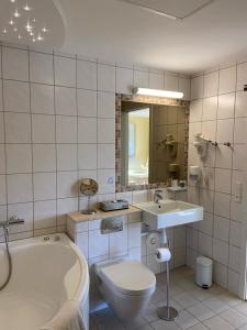 a bathroom with a tub and a toilet and a sink at Montra Odder Parkhotel in Odder +57 photos
