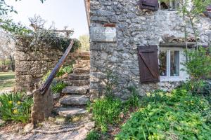 a stone house with a sign on the side of it at Rustic Art House Kras Krk in Kras