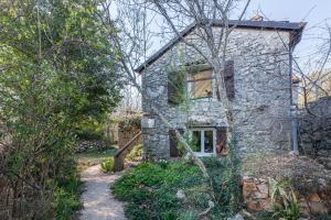 a stone house with a window on the side of it at Rustic Art House Kras Krk in Kras