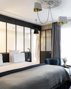 a bedroom with a large bed and a chair at Terrass" Hotel in Paris