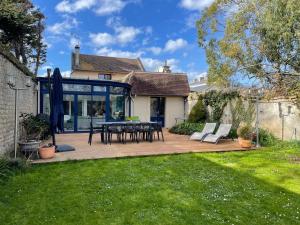 a patio with a table and chairs in a yard at Balaena - maison avec jardin proche plage in Luc-sur-Mer
