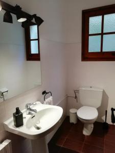 a bathroom with a white sink and a toilet at La Casa de les Oques in Espinelvas
