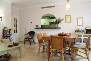 a kitchen and living room with a table and chairs at Apartamento de lujo en la playa in Oliva
