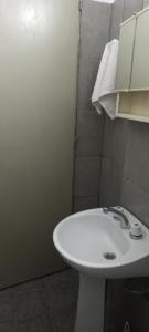 Un baño con un lavabo blanco y un espejo. en Urquiza 575, en Concepción del Uruguay