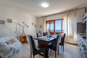 a living room with a dining room table and chairs at SARDINIA RE - Anglona Apartment in Castelsardo