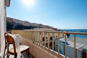 a balcony with two chairs and a view of the ocean at SARDINIA RE - Anglona Apartment in Castelsardo